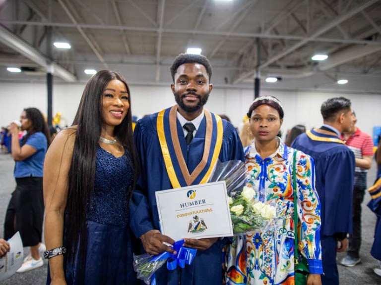 Graduate takes photo with two ceremony guests