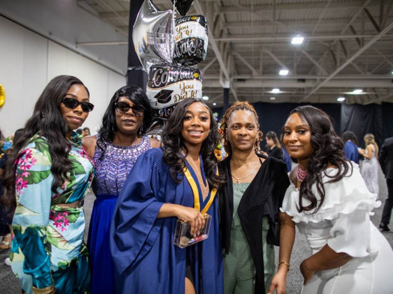 Graduate poses with four guests