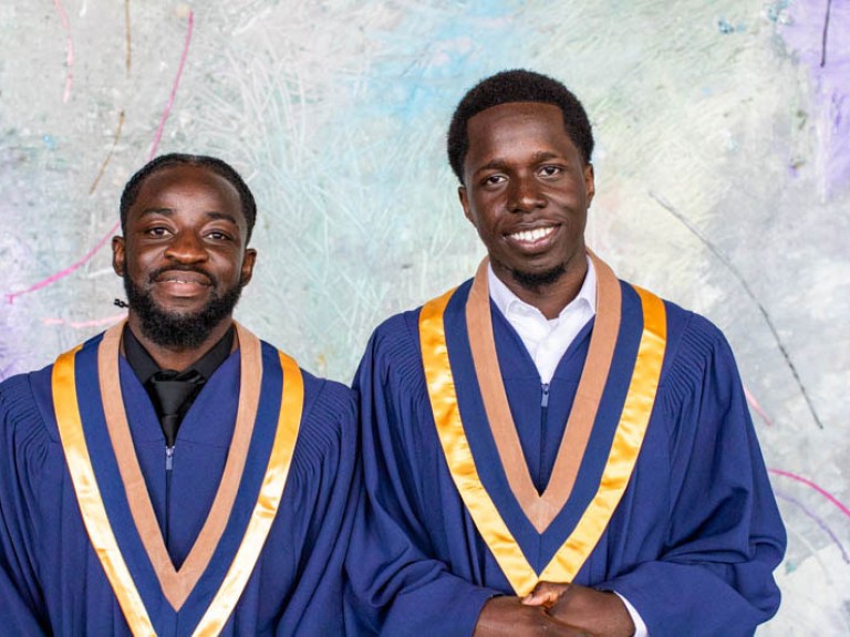 Two graduates smile for camera