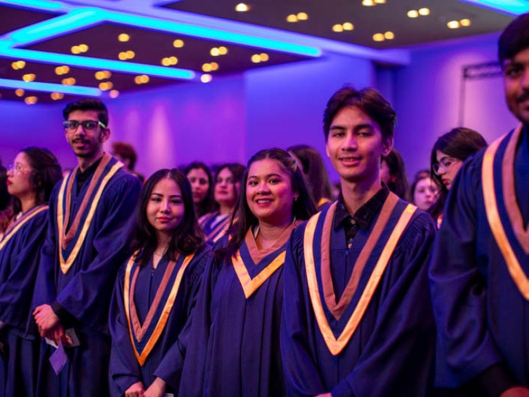 Graduates standing in ceremony audience