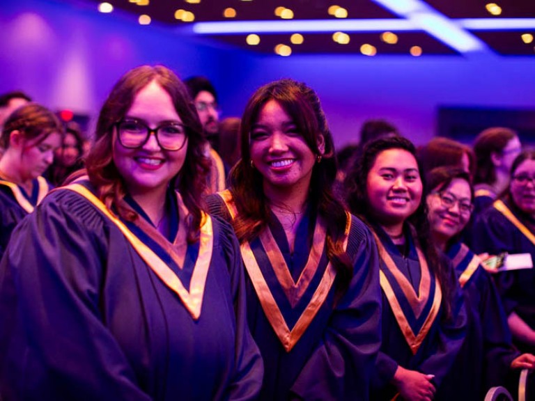 Graduates smile at camera