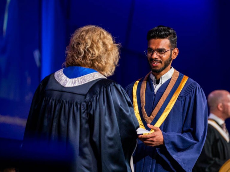 Graduate receives their certificate from Humber president on stage