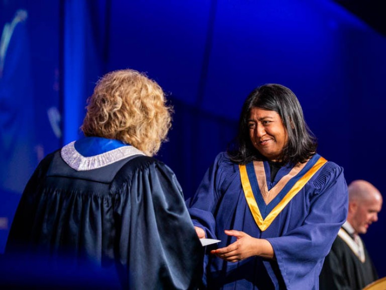 Graduate receives certificate on stage