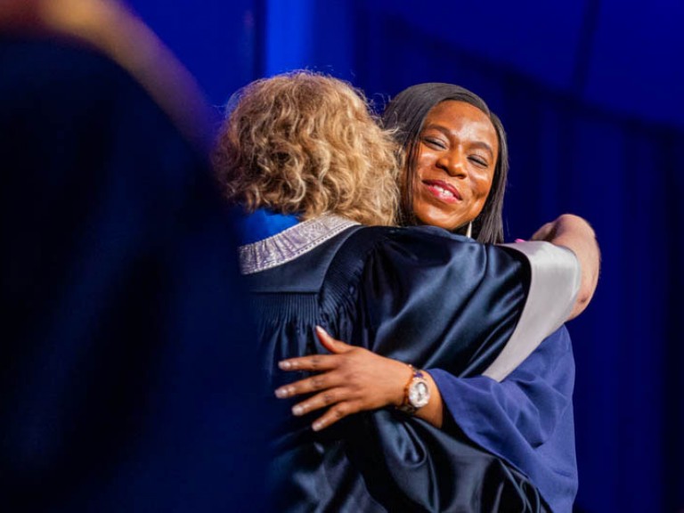 Graduate hugs Humber president Ann Marie Vaughan on stage