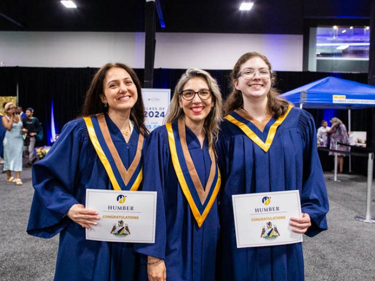 Three graduates pose for photo