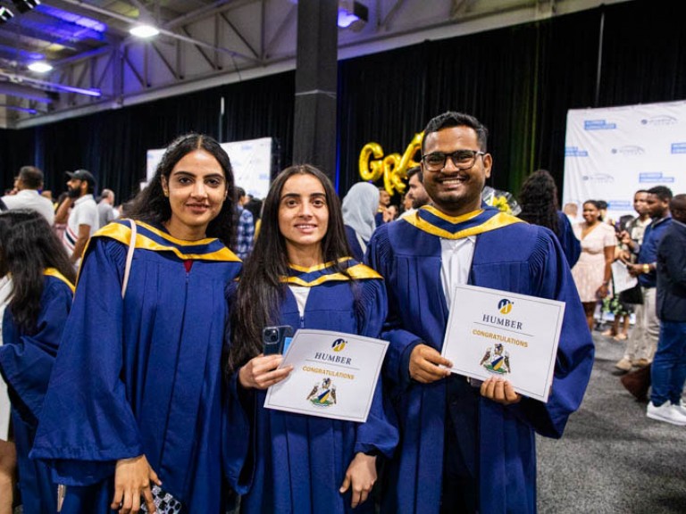 Three graduates pose for photo