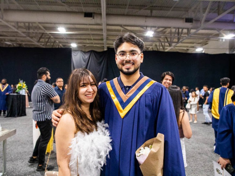 Graduate poses with guest for photo
