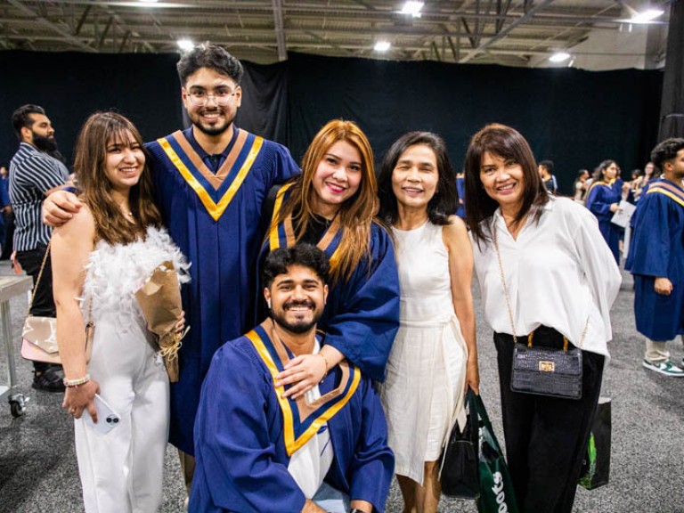 Three graduates pose with three guests