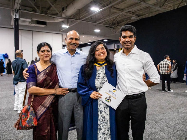 Graduate poses with three family members