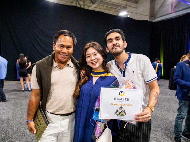 Graduate poses with two guests