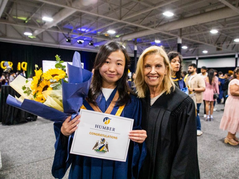 Graduate poses with Humber faculty member