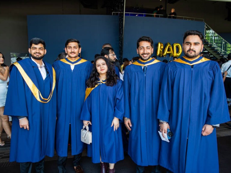 Five graduates pose for camera