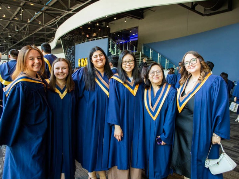 Six graduates smile for camera