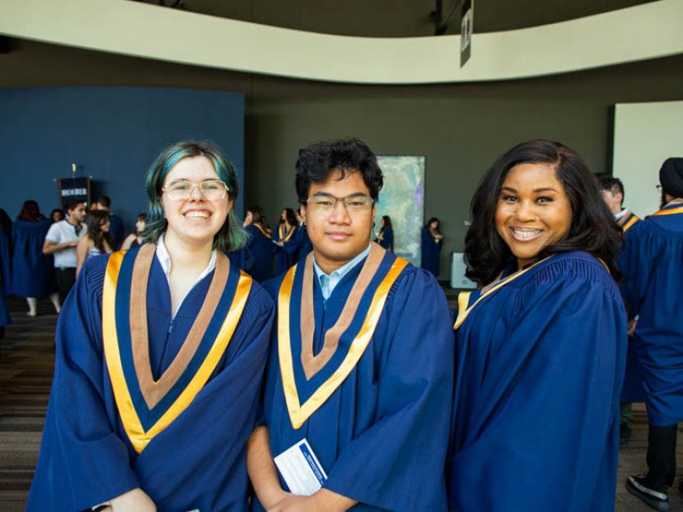 Three graduates pose for camera
