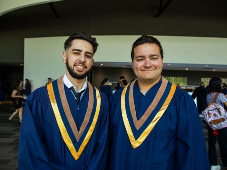 Two graduates pose for camera