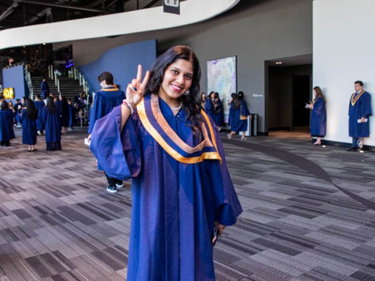 Graduate holds up peace sign