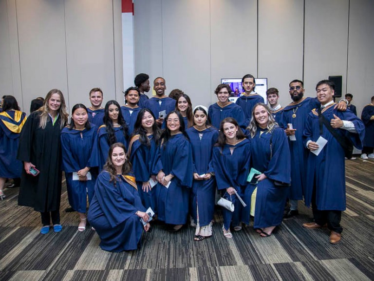 Large group of graduates smile for camera