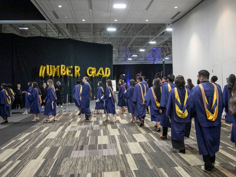 Graduates proceed in line into ceremony hall