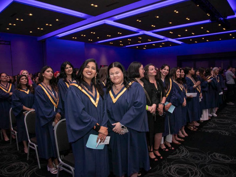 Graduates in ceremony hall standing