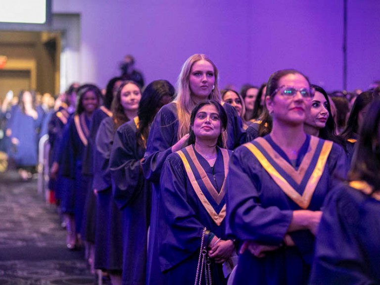 Graduates standing in ceremony hall