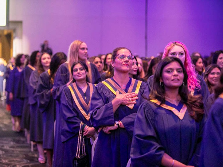 Graduates standing in ceremony hall