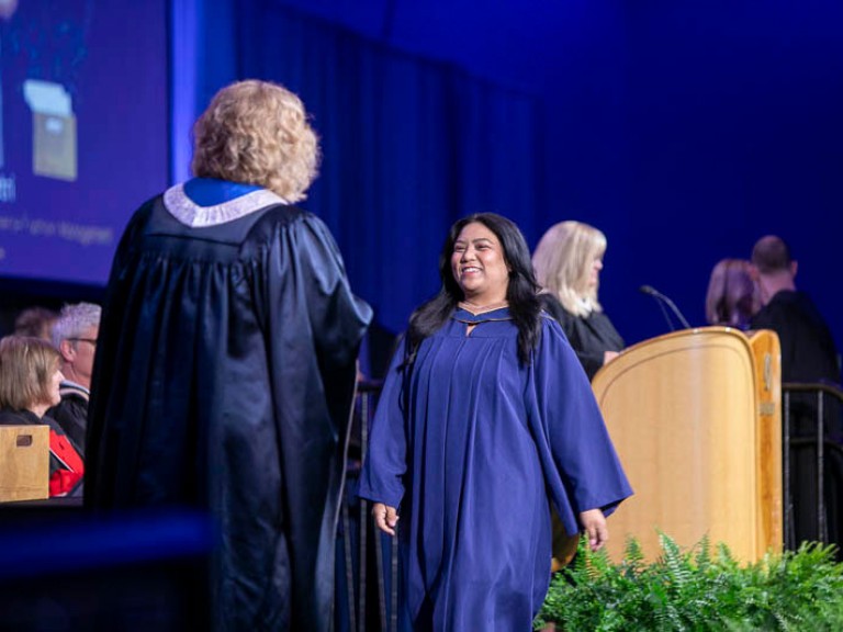 Graduate crosses stage to receive certificate