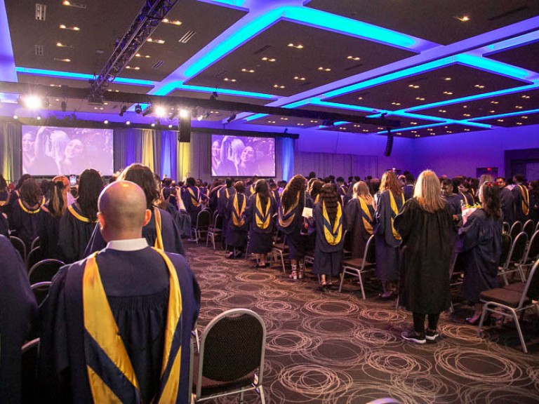 Graduates standing in the audience