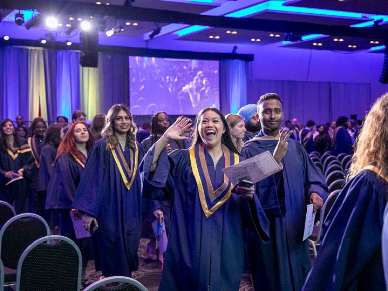 Graduates proceed out of ceremony hall