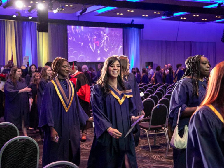 Graduates proceed out of ceremony hall