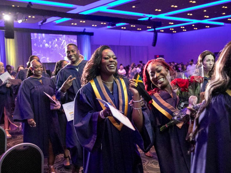 Smiling graduates proceed out of ceremony hall