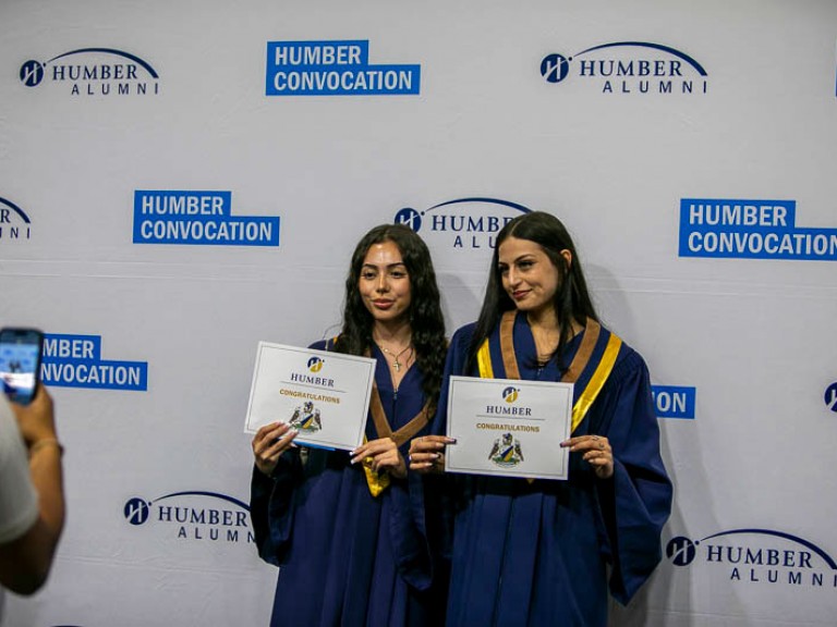 Two graduates pose for photo