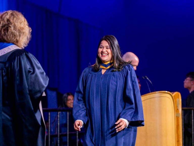 Graduate crosses stage to receive credential