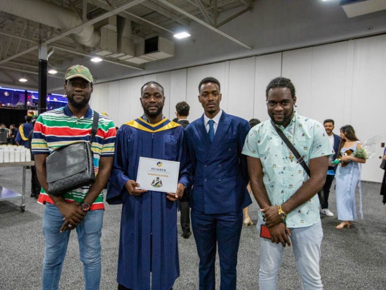 Two graduates and two guests stand for photo