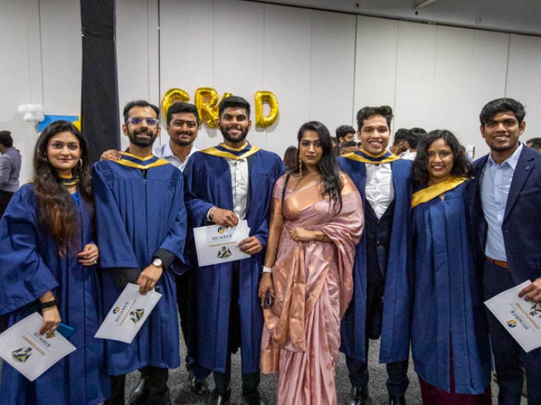 Five graduates pose with three guests