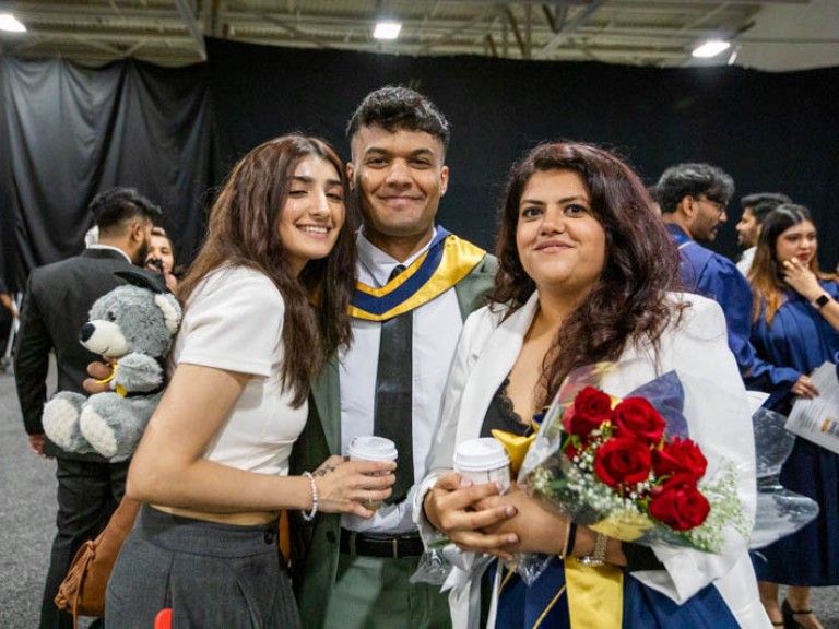 Graduate poses with two guests