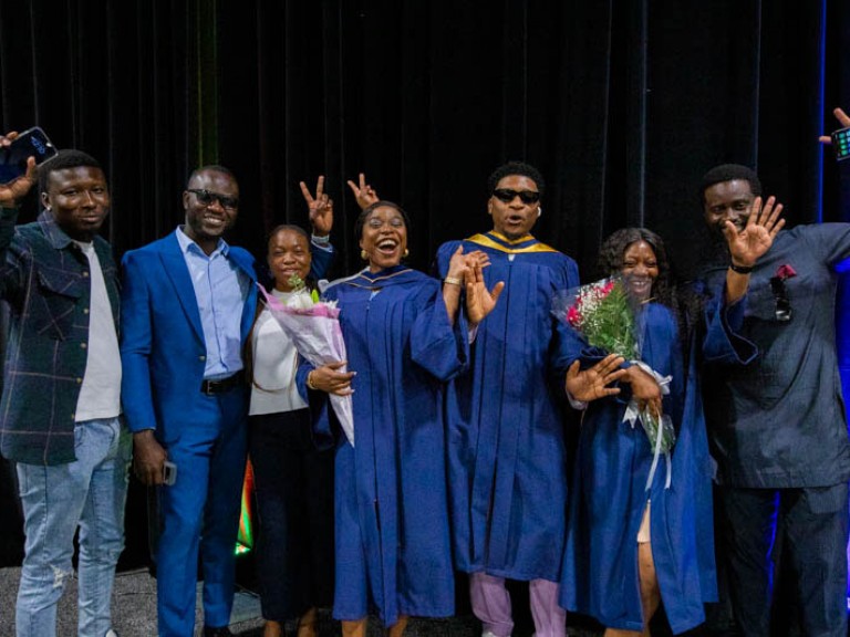 Seven people raise hands in excitement