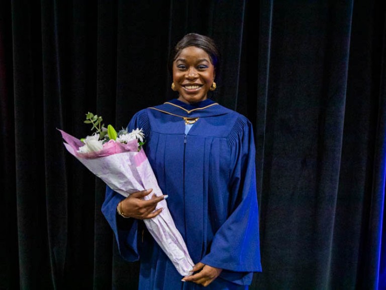 Graduate holding flowers