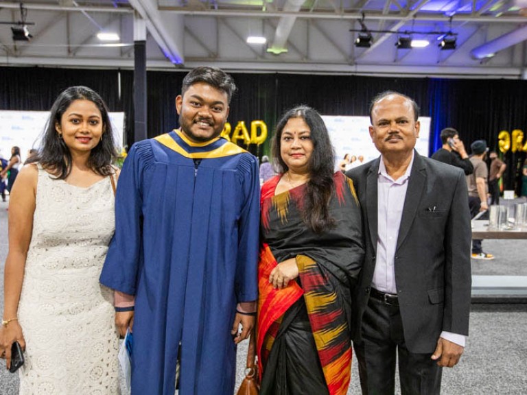 Graduate poses photo with three family members