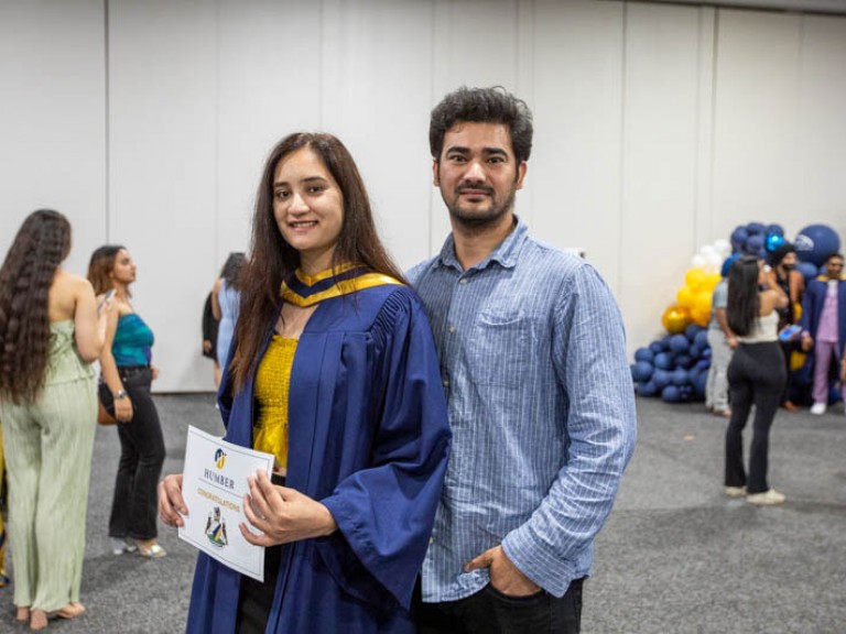 Graduate poses with guest for camera