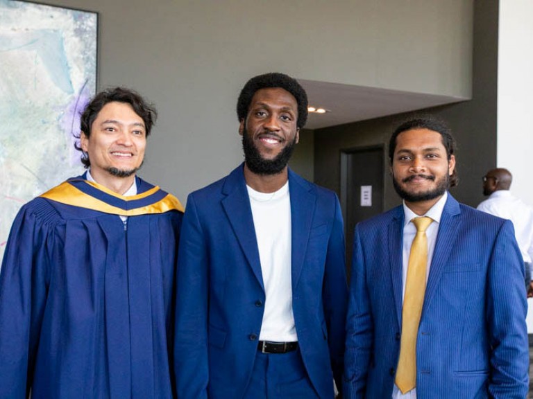 Three graduates stand for photo together