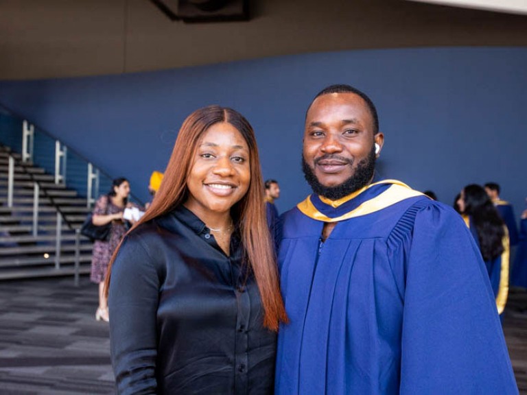 Graduate and guest pose for photo