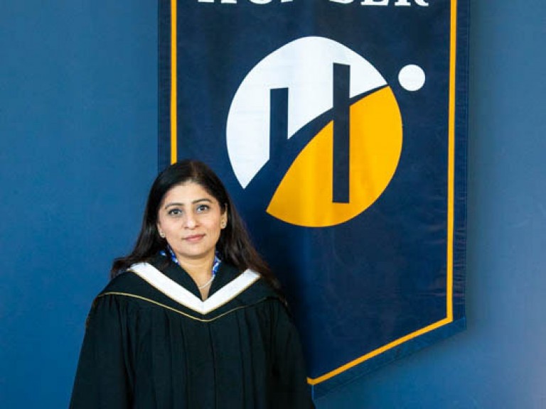 Honorary degree recipient Deepa Mattoo in front of Humber flag
