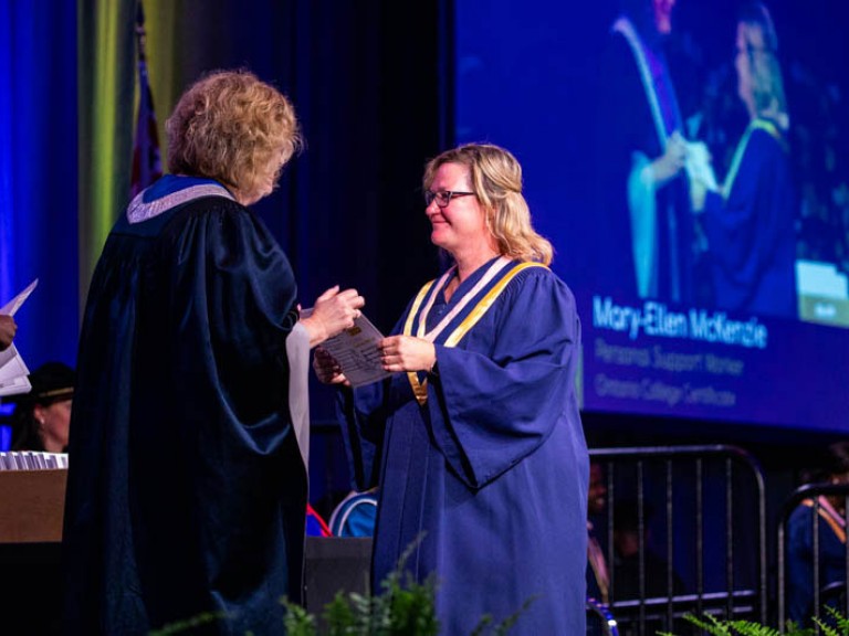 Graduate receives certificate from Humber president