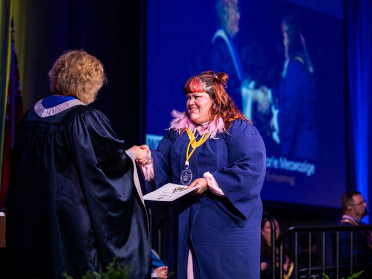 Graduate receives certificate from Humber president