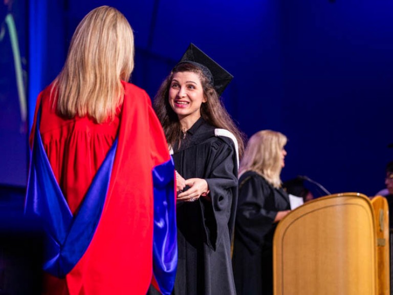 Graduate on stage with Humber faculty member