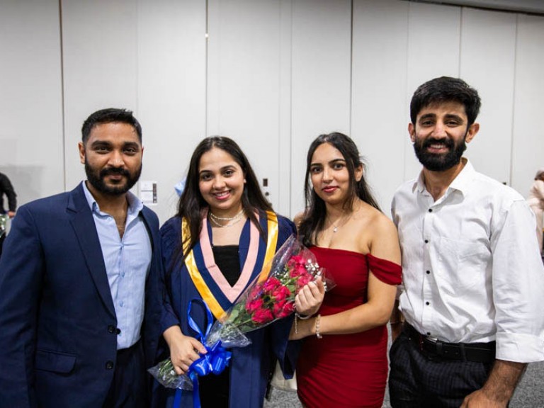 Graduate poses with three guests