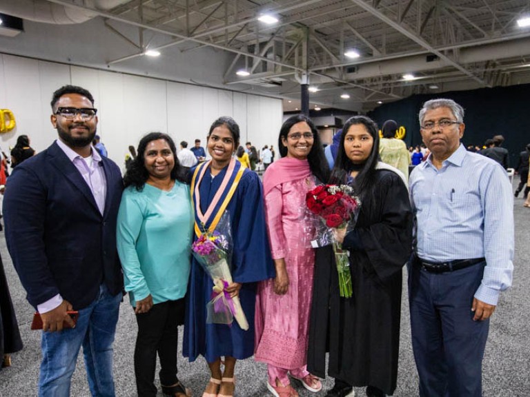 Graduate poses with family members