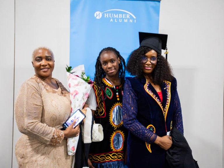 Graduate poses with two others
