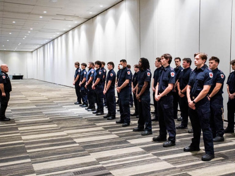 Class of graduates from police program stand in uniform