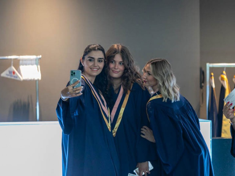 Three graduates taking a selfie together